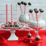 Chocolate Peppermint Cake Pops displayed on cake plate and vases on a red table cloth