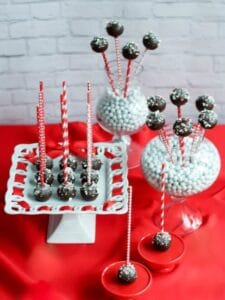 Chocolate Peppermint Cake Pops displayed on cake plate and vases on a red table cloth