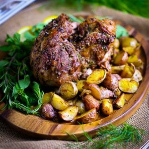 Boneless Roasted Leg of Lamb with Potatoes and Fennel on a wood serving board.