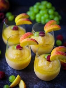 Four Peach Sangria Slushies all poured and garnished.