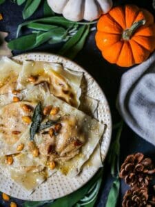 Over head shot of Butternut Squash Ravioli with pumpkins and sage leaves around.