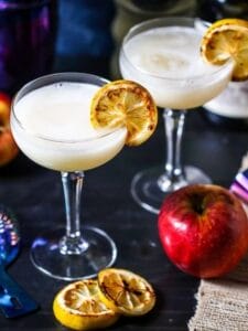 Ginger Apple Cocktails on a table with charred lemons and apples.