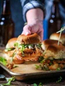 Buffalo Chicken Slider being held in a hand and presented for eating.