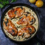 Chicken Breasts with Creamy Spinach Sauce cooked in a cast iron skillet.