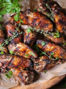 Garlic and Herb Grilled Chicken Wings charred and garnished with fresh herbs