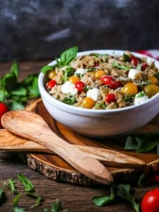 Italian Pasta Salad in a large bowl with wooden tongs for serving.