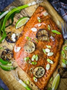 Overhead shot of Soy and Lime Grilled Salmon scattered with lime slices and scallions.