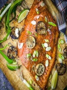 Overhead shot of Soy and Lime Grilled Salmon scattered with lime slices and scallions.