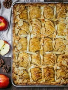 Overhead shot of Caramel Apple Slab Pie baked on a half sheet tray decorated with pastry leaves and twists.