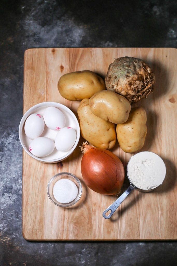 Ingredients for celery root latkes including celery root, potatoes, onion, flour, salt and eggs.