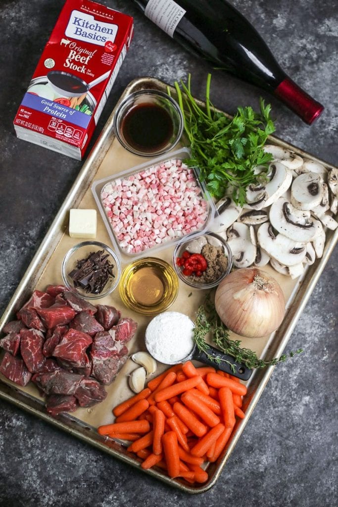 Gather ingredients for Beef Bourguignon including beef, stock, wine, pancetta, and vegetables.