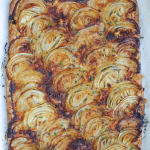 A tender pastry crust topped with sweet roasted onions and just a hint of herbs make this French onion tart a party favorite. A sprinkle of thyme and a handful of gruyere pair deliciously with caramelized onions.