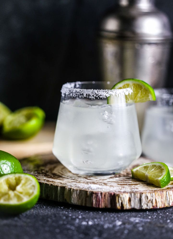 Close up a of a classic margarita garnished with salt and lime.