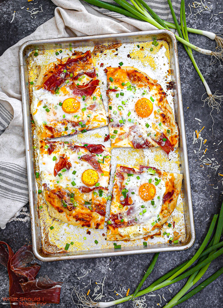 Ham, Egg and Cheese Breakfast Pizza golden, baked and sliced on a sheet tray.