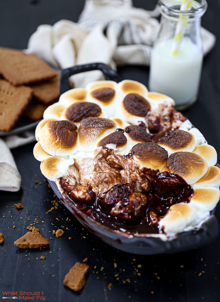 S'mores Dip that's been partially eater with graham crackers scattered around.