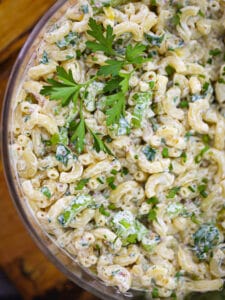 Close up shot of classic macaroni salad garnished with parsley.