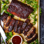 Grab extra napkins! These oven roasted baby back ribs are tender, melt-in-your-mouth goodness slathered in tangy bourbon BBQ sauce.