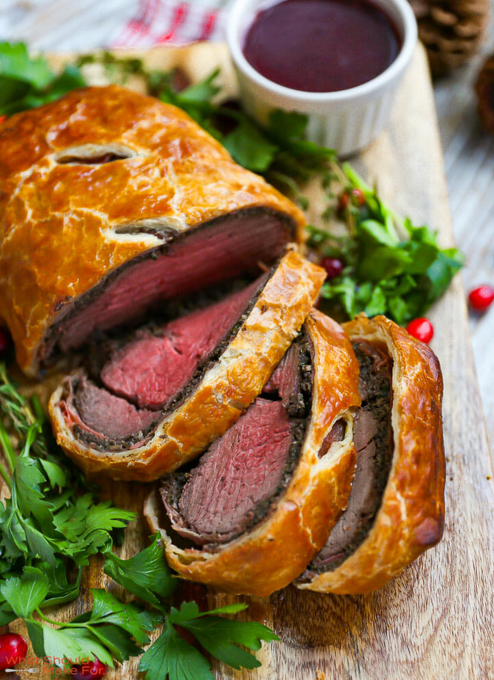 Close up of a sliced Beef Wellington with Red Wine Sauce.