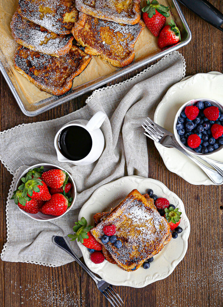 Overhead shot of Brioche French Toast on a plate with strawberries, raspberries and blueberries.