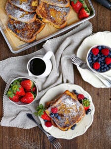 Overhead shot of Brioche French Toast on a plate with strawberries, raspberries and blueberries.