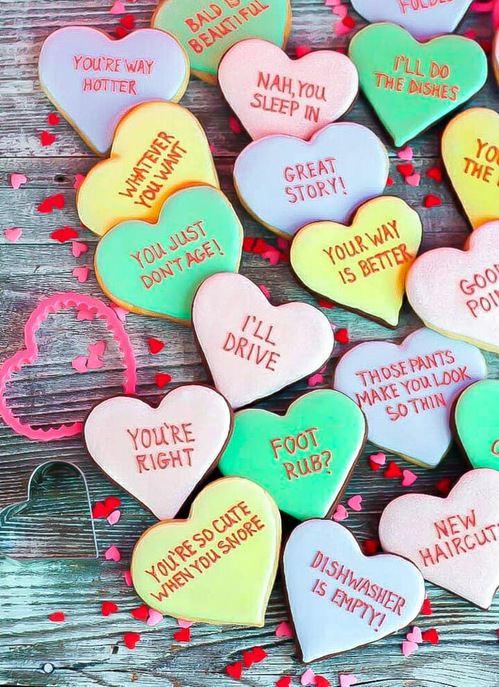 Vanilla and chocolate Conversation Heart Cookies inscribed with funny messages.