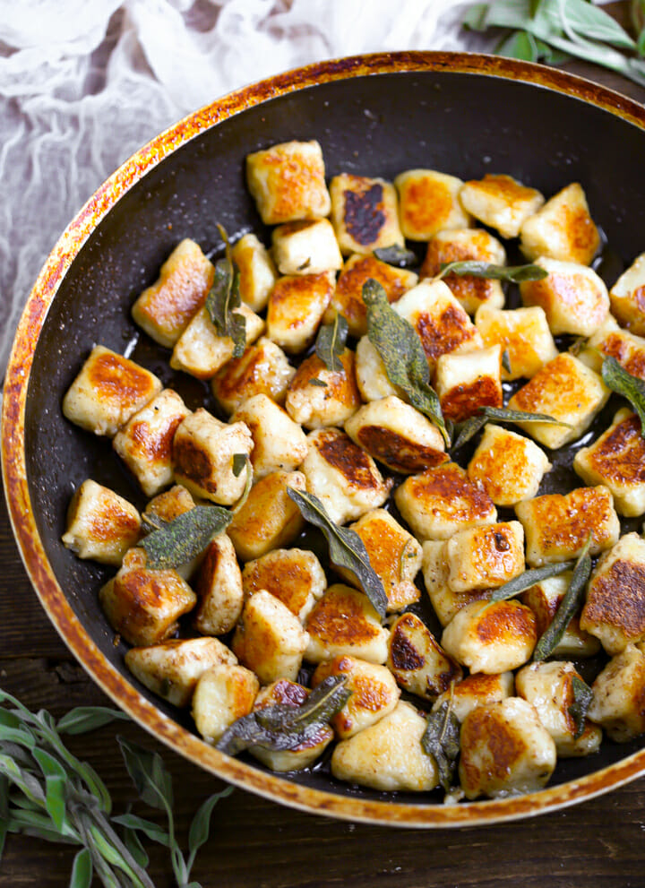 Pan Seared Gnocchi in a pan topped wit frizzled sage leaves.