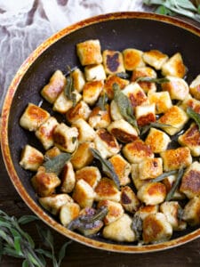 Pan Seared Gnocchi in a pan topped wit frizzled sage leaves.