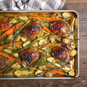 Overhead view of mustard glazed chicken on an sheet pan with roasted vegetables.