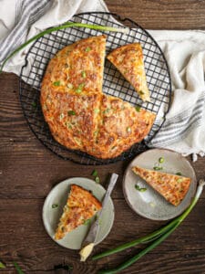 Cheddar and Scallion Soda Bread with three wedges cut out.
