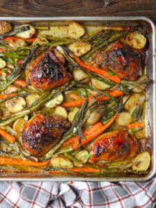 Overhead view of mustard glazed chicken on an sheet pan with roasted vegetables.