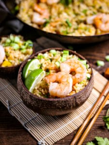 A serving of shrimp fried rice with chop sticks alongside.