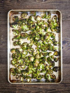 Roasted broccoli on a sheet pan browned and crisp.