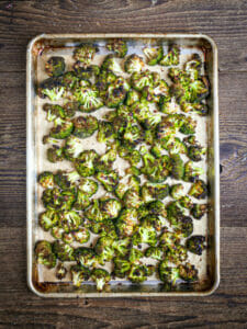 Roasted broccoli on a sheet pan browned and crisp.