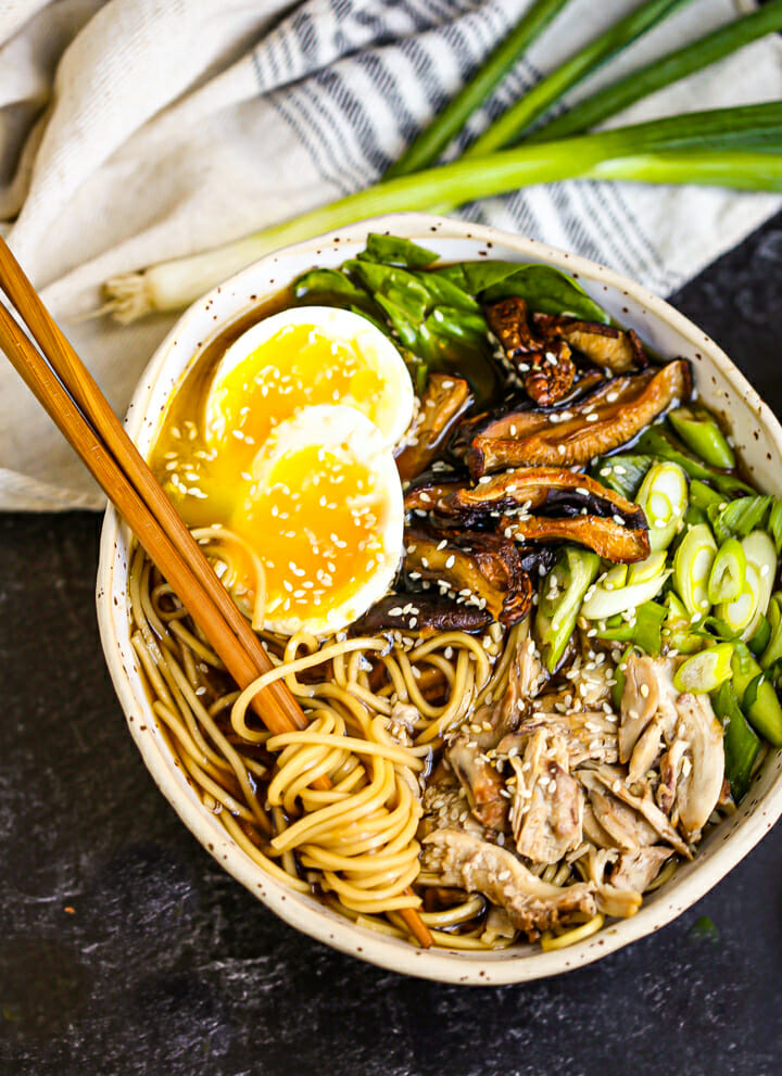 A bowl of Homemade Chicken Ramen with noodles twirled around chopsticks.