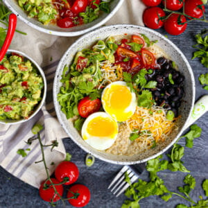 A Mexican Breakfast Bowl with Oatmeal topped with a six minute egg and guac on the side.