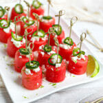 Margarita Watermelon Bites served on a white platter garnished with lime zest.