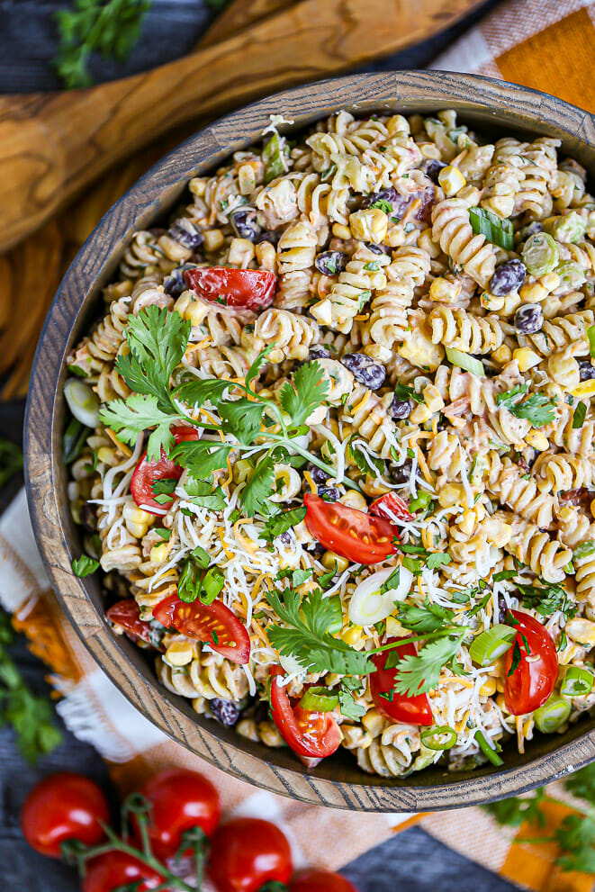 Close up shot of a bowl of Tex-Mex Pasta Salad garnished with cilantro and baby tomatoes.