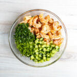 The shrimp, cucumber and herbs in a bowl for shrimp salad.