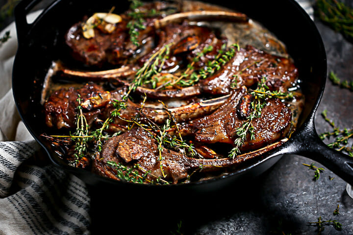 Lamb chops are seared and basted with garlic butter.