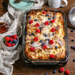 Baked French toast casserole on the table with berries and maple syrup.