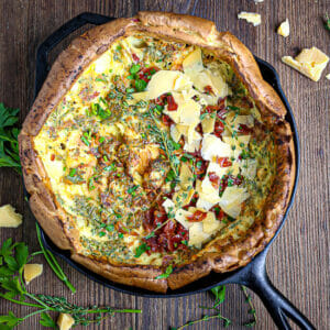Savory Dutch Baby with Gouda and Crispy Prosciutto in a cast iron skillet.