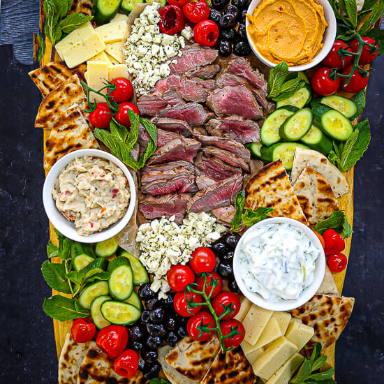 Mediterranean Mezze Platter with Rosemary Garlic Grilled Lamb, dips, pita and vegetables.