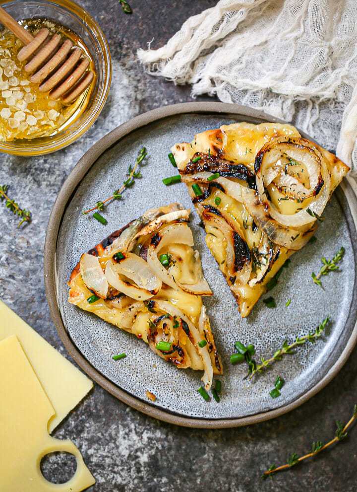 Two wedges of grilled swiss flatbread on a plate.