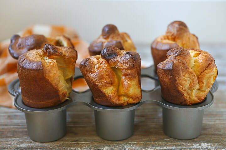 Popovers risen and golden in a popover pan.