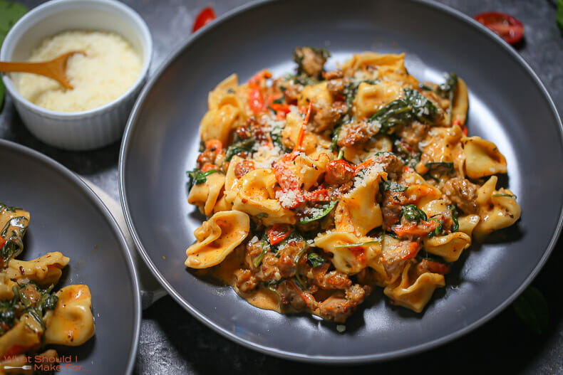 Dig into this bowl of Creamy Sausage Tortellini with Spinach and Tomatoes.