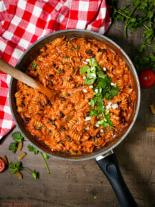 Overhead shot of a pot of Southwest Turkey Pasta with a wooden spoon.